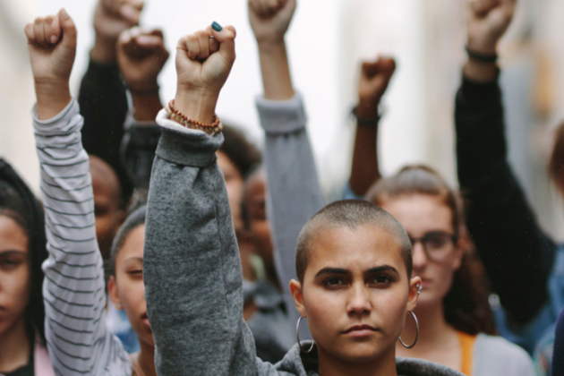 Group of diverse people raising their fists in solidarity.