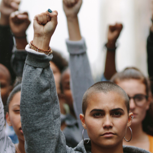 Group of diverse people raising their fists in solidarity.